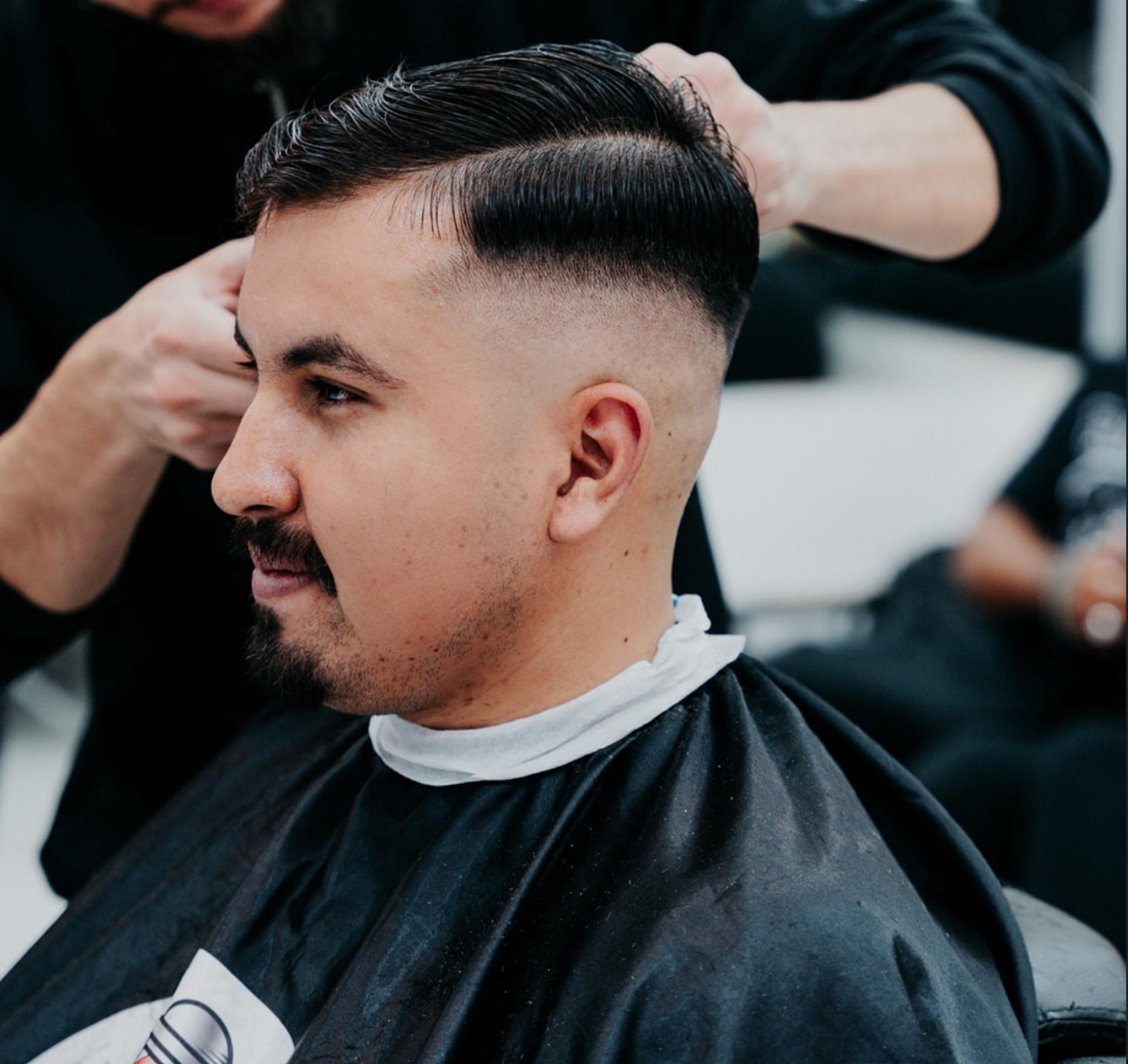 Stylist finishing a guest's cut inside Black Sea Friseur