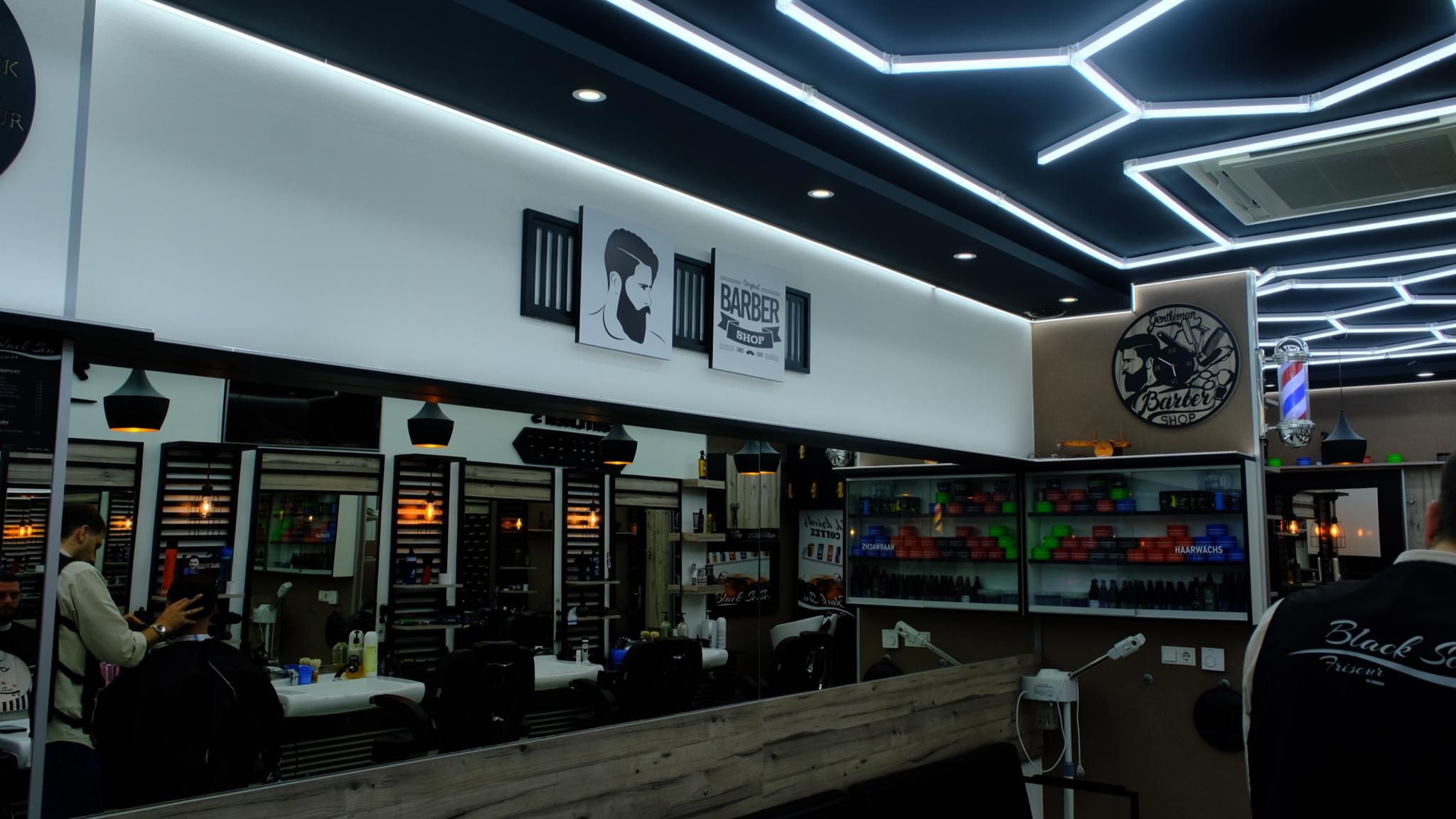 Barber area with statement ceiling lighting at Black Sea Friseur